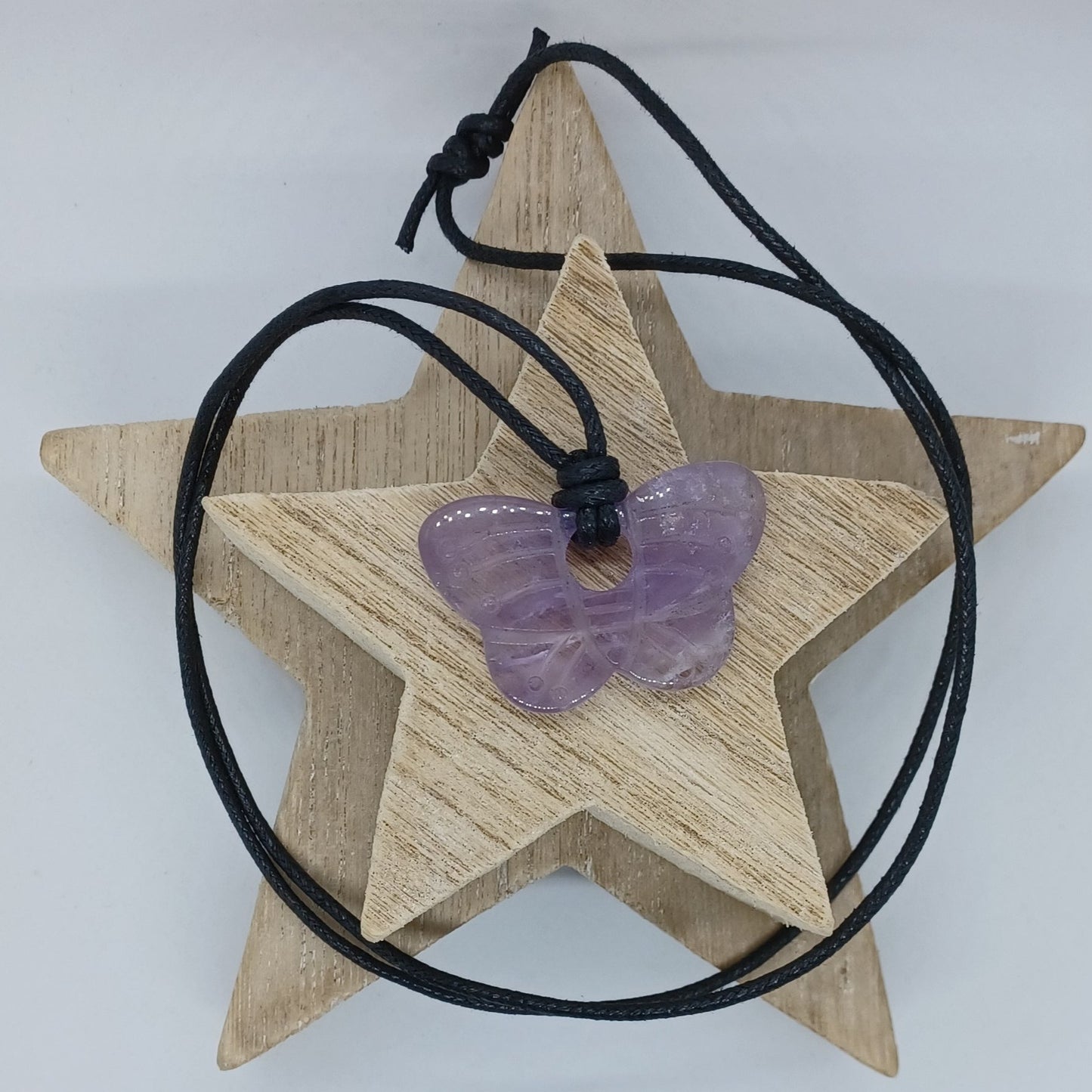 Amethyst butterfly necklace with sliding knots. The necklace is made from black cotton cord 2 mm thick. The butterfly is a beautiful light purple colour.